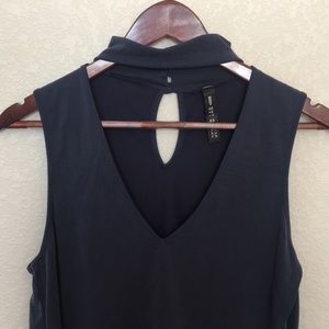 Navy blue sleeveless shirt with choker neckline.